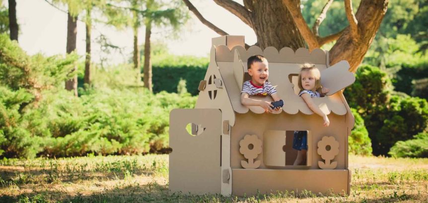 SEO for self storage, with kids playing in a cardboard house made out of storage moving boxes