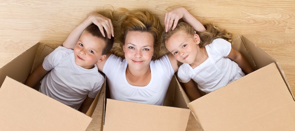Smiling family playing in self-storage cardboard boxes